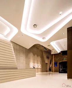 A minimalistic lobby interior with concrete walls, glass elements, and sleek design.