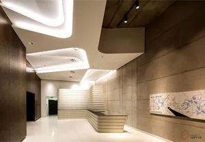 An image depicting a modern office reception area with concrete walls and a sleek, white reception desk.