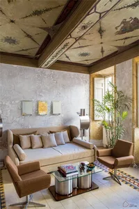 A modern residential living room featuring concrete walls and wood accents.
