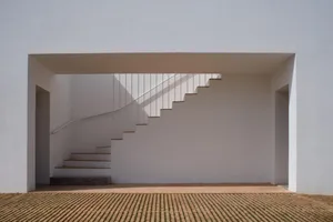 Modern white concrete staircase with white railings.