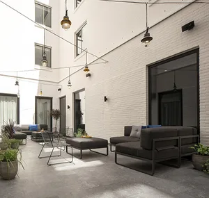 Industrial outdoor lounge area with concrete flooring and seating.