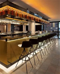 A modern bar counter made of metal with LED lighting underneath the seating area.