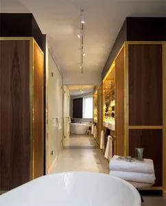 A modern bathroom suite featuring a freestanding bathtub, wooden cabinets, and glass elements.