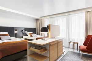 A modern bedroom featuring a wooden desk, bed, and chair.