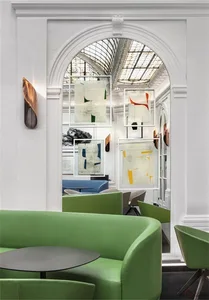 Modern cafe interior with green leather seating and abstract artwork