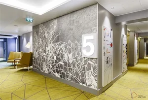 Modern hotel lobby interior with concrete walls and abstract wall art.