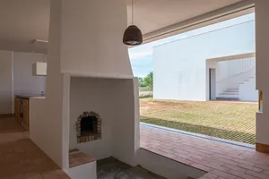 Modern interior with concrete walls and a brick patio.