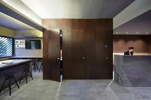 A modern office reception desk with wooden panels and a concrete countertop.