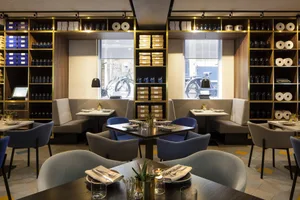 Modern restaurant interior with glass shelves, comfortable seating, and stylish decor.
