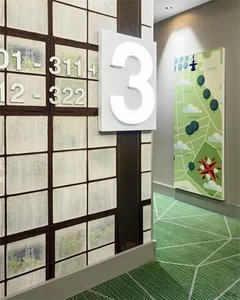 A hallway with a wallpapered wall featuring numbers and a map.