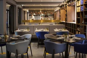 A modern restaurant interior with neutral tones and contemporary furniture.