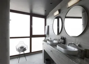 A minimalist bathroom featuring concrete and glass materials with large windows.