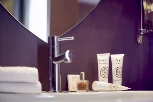 A minimalist bathroom scene featuring ceramic accessories, including a sink faucet and toiletries.