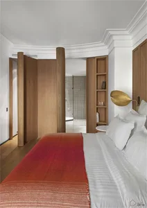 A modern minimalist bedroom with wooden flooring, glass walls, and metal accents.