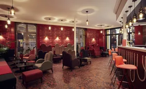 A modern restaurant interior with metal accents, wood furnishings, and glass walls.