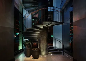 Spiral staircase with metal railing in an industrial-style space.
