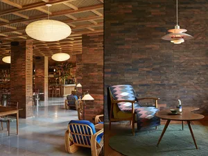 Modern industrial-style lounge area with brick accent wall and unique furniture.