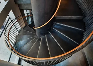 Industrial spiral staircase constructed from metallic and wooden materials