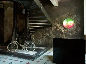A minimalist interior design featuring metallic stairs and concrete floors.