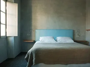 Modern residential bedroom featuring a concrete headboard and minimalist design.