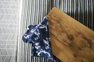 A navy blue fabric basket with white bird patterns on a striped surface.