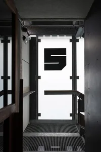 Modern minimalist metal interior with a large black 'S' logo and grid floor