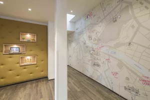An office space featuring a large, detailed city map displayed on the wall, with decorative shelving units mounted on the adj