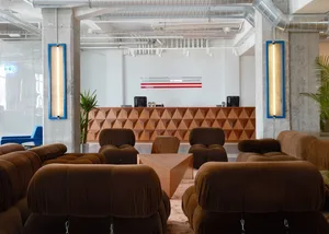 A spacious industrial-style officeITOR with a modern wooden reception desk and comfortable seating arrangements.
