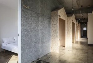 Minimalist residential corridor featuring concrete textured walls.