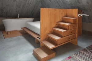 Industrial design bedroom with wooden bed platform and stairs