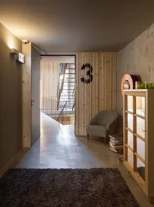 A modern industrial lobby with concrete flooring, wooden walls, and a minimalist design.