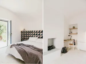 A minimalist bedroom with a bed, blanket, and a fireplace with shelves and a desk.