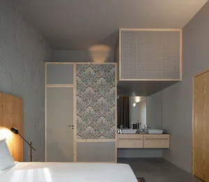 A minimalist bedroom featuring plaster walls and wooden furniture.