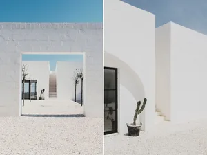 Modern minimalist white plaster exterior with arches and gravel pathway