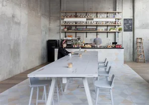 A modern coworking space featuring wheelchair accessibility, with concrete walls and wooden furniture.