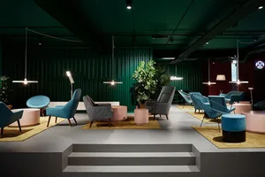A modern living room with a mix of fabric, metal, wood, and concrete furniture.
