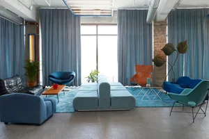 Contemporary office space featuring blue textiles and modern furniture.