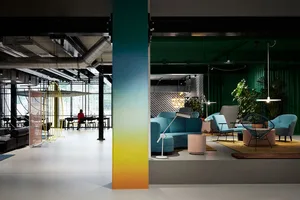 Modern lobby with white floors, blue furniture, and concrete accents.