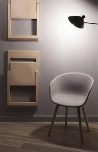 Modern minimalist interior design with a fabric chair and foldable chairs on the wall.