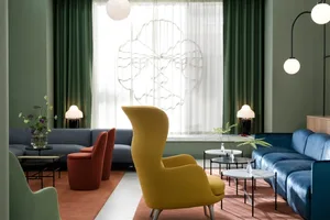 Modern lobby with fabric armchairs, glass tables, and metal legs