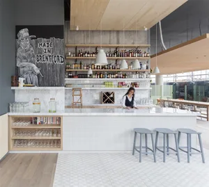 Modern restaurant bar interior with marble countertops, concrete walls, and hanging pendant lights
