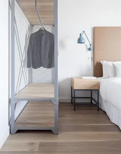 Industrial-style bedroom with floating wooden shelves, modern bed, and minimalist decor.