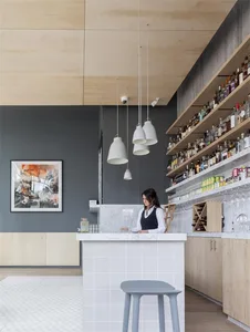 Contemporary coffee shop interior with marble counter, concrete walls, and wood accents.