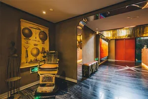 Industrial-style lobby featuring a leather upholstered chair, metal accents, and concrete flooring.