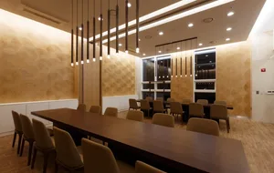 A modern conference room featuring long wooden tables and chairs.
