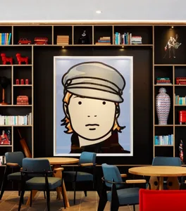 Lobby featuring a modern design with industrial elements, including a large framed artwork of a person wearing a hat, shelves