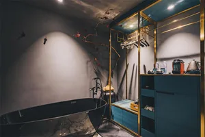 A minimalist bathroom with a marble bathtub, modern fixtures, and sleek, dark furnishings.