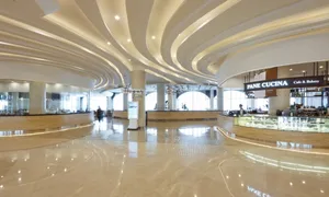 A modern restaurant interior with marble floors and curved lighting features