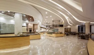 Modern restaurant interior with marble flooring and walls, featuring contemporary design elements.