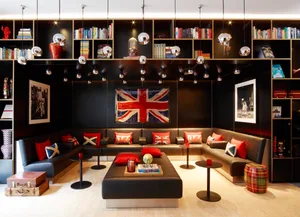 A modern lounge area with a library wall, British flag, and British-themed cushions.
